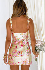 Rear view of a yellow floral satin mini dress with a square back and decorative flower appliques on the spaghetti straps