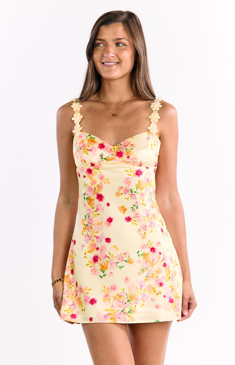Yellow satin mini dress with a sweetheart neckline, pink and orange floral print, and floral-shaped shoulder straps