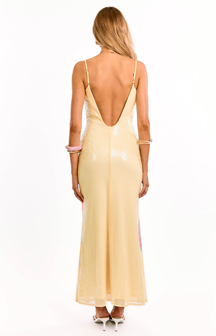 Rear view of a yellow sequin maxi dress with a low scoop back and thin adjustable spaghetti straps