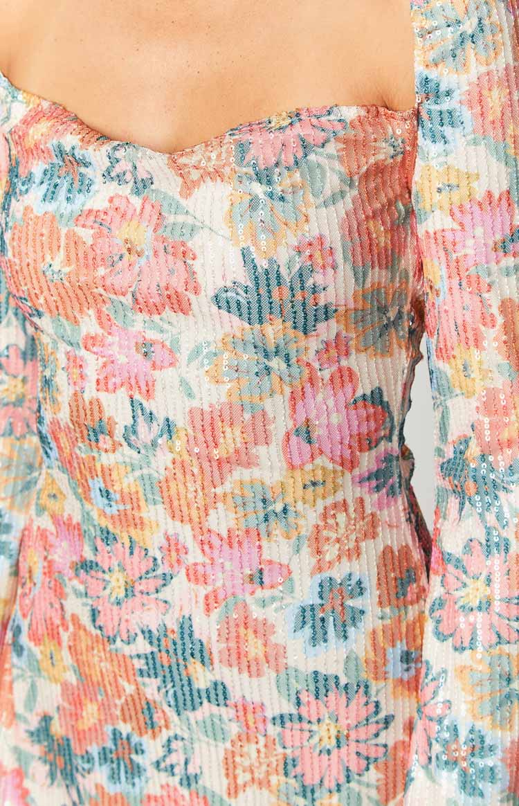 Close-up of the sweetheart neckline and the pink, orange, blue floral sequin pattern of the mini dress