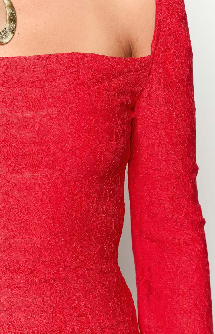 Close-up of the red floral lace fabric, showing the square neckline and long sleeve of the mini dress