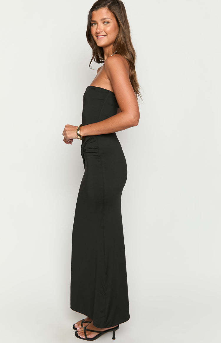 Side view of a black strapless maxi dress showing the ruched detail at the waist and fitted silhouette