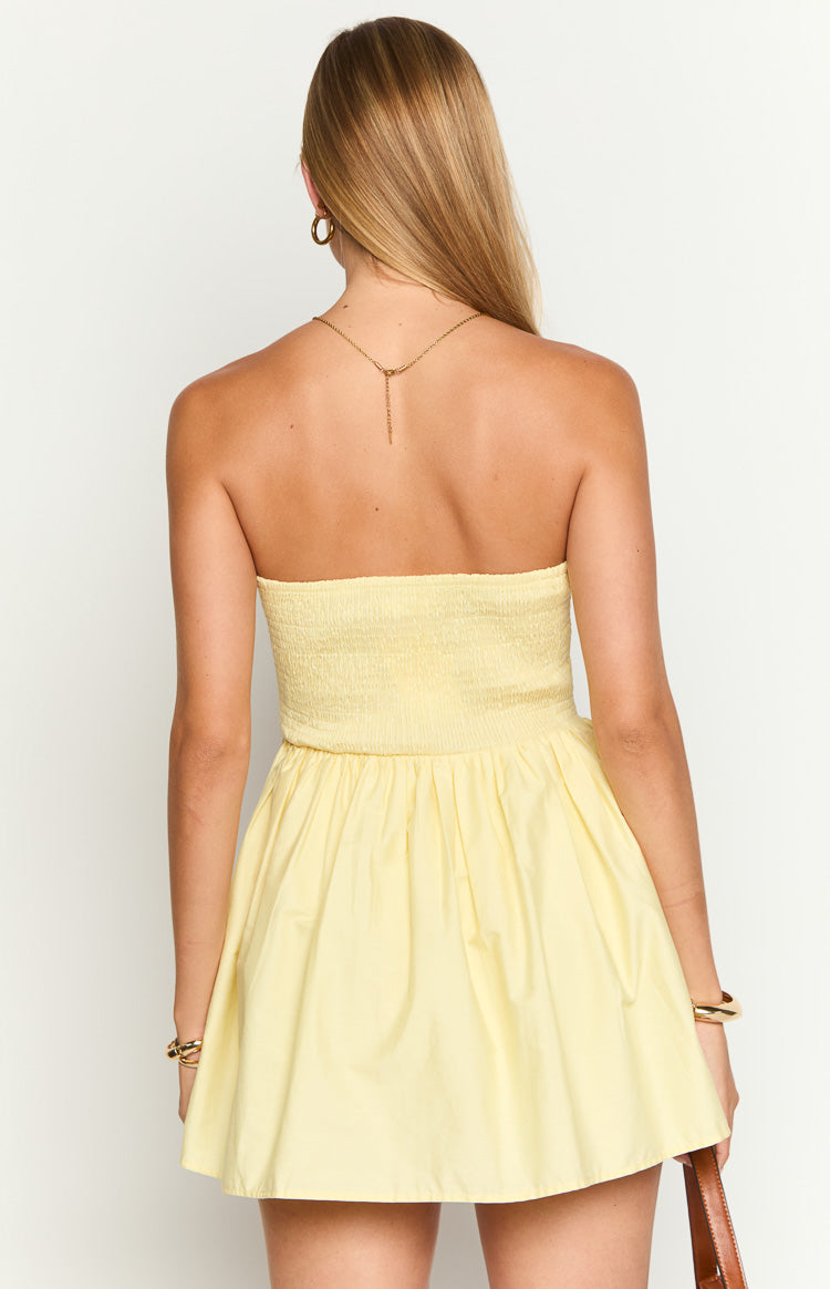 Rear view of a yellow strapless mini dress with a shirred bodice and gathered skirt