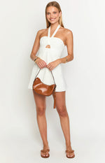 White mini dress with a halter neckline, ruched bust, front cutout, and a flowy A-line skirt