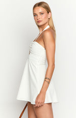 Side view of a white textured mini dress showing the ruched halter neckline, fitted bodice, and flared A-line skirt