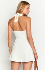 Rear view of a white textured mini dress with a halter neck tie and open back