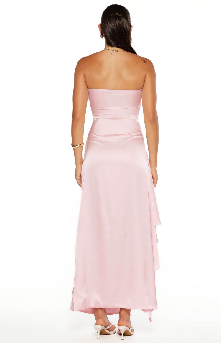 Rear view of a light pink strapless maxi dress with a fitted bodice and a flowing skirt with a ruffled side detail
