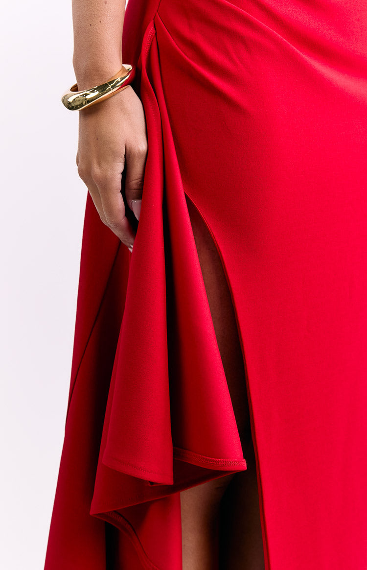 Detail shot of the high side slit and flowing draped fabric on a red crepe maxi dress