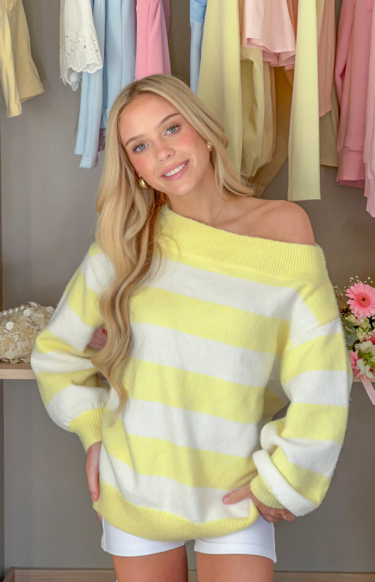 Front view of a yellow and white striped off-shoulder knit sweater with a ribbed neckline and cuffs