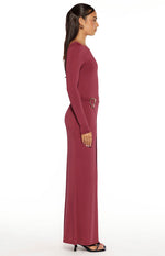 Side view of a burgundy long sleeve wrap maxi dress with a gold heart buckle detail at the waist