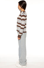 Side view of a brown, blue, and white striped button-down cardigan with ribbed cuffs and a fitted silhouette