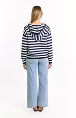 Rear view of a navy and white striped knit sweater with a hood and ribbed hem