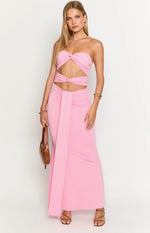 Front view of a pink strapless maxi dress with twisted knot bust, midriff cutouts, and a ruched waist with draped panel