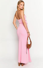 Side view of a pink strapless maxi dress with a fitted silhouette, highlighting the side cutout and ruched bodice