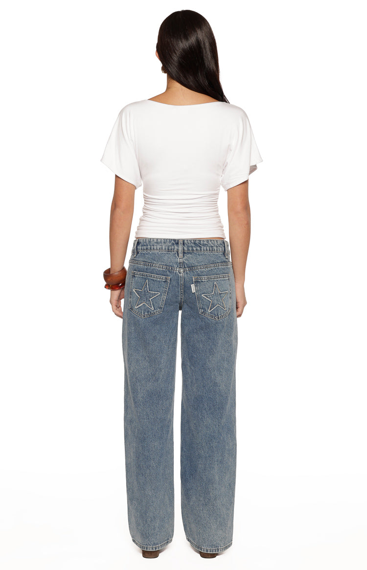 Rear view of a white jersey top with a boat neckline and short dolman sleeves, showing the ruched waist detail