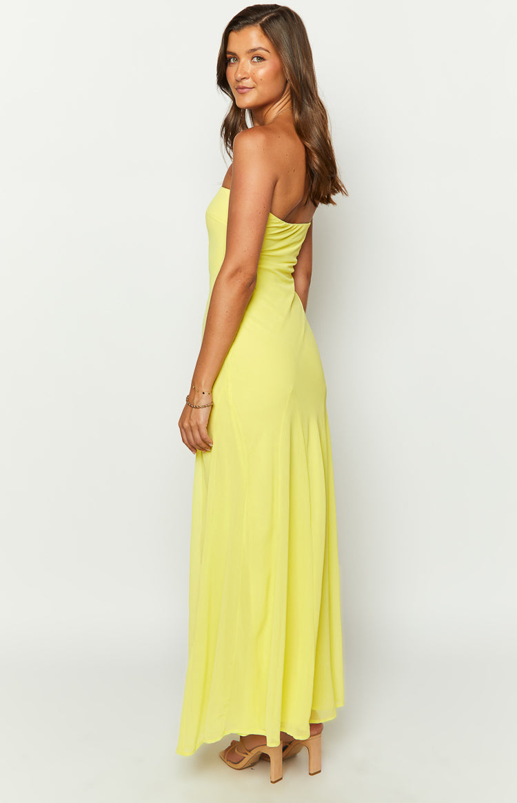 Side view of a yellow strapless maxi dress with a fitted bodice and flowy skirt