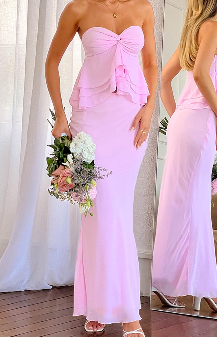 Light pink maxi skirt with a smooth, fitted silhouette through the hips and a flowing hem