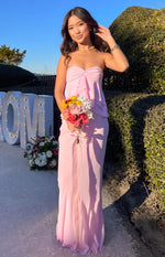Front view of a light pink maxi skirt with a flowing silhouette and a subtle ruffled hem