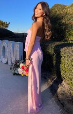 Side view of a pink flowy maxi skirt with a high waist and a long side slit revealing a satin ribbon detail