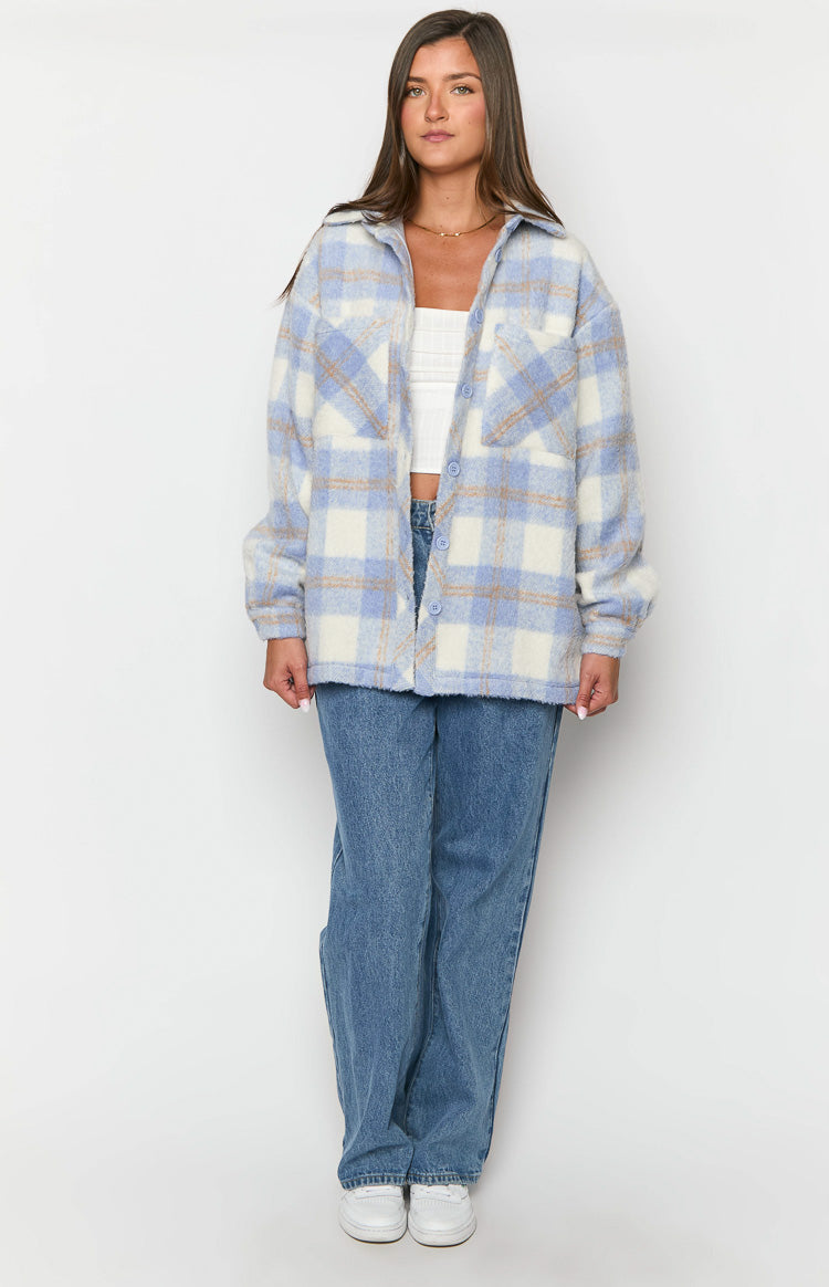 Front view of an oversized blue, white, and brown check jacket worn open, highlighting the fuzzy texture and chest pockets