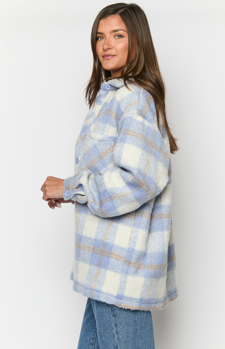 Side view of an oversized blue and white check jacket with a fuzzy texture and buttoned sleeve cuff