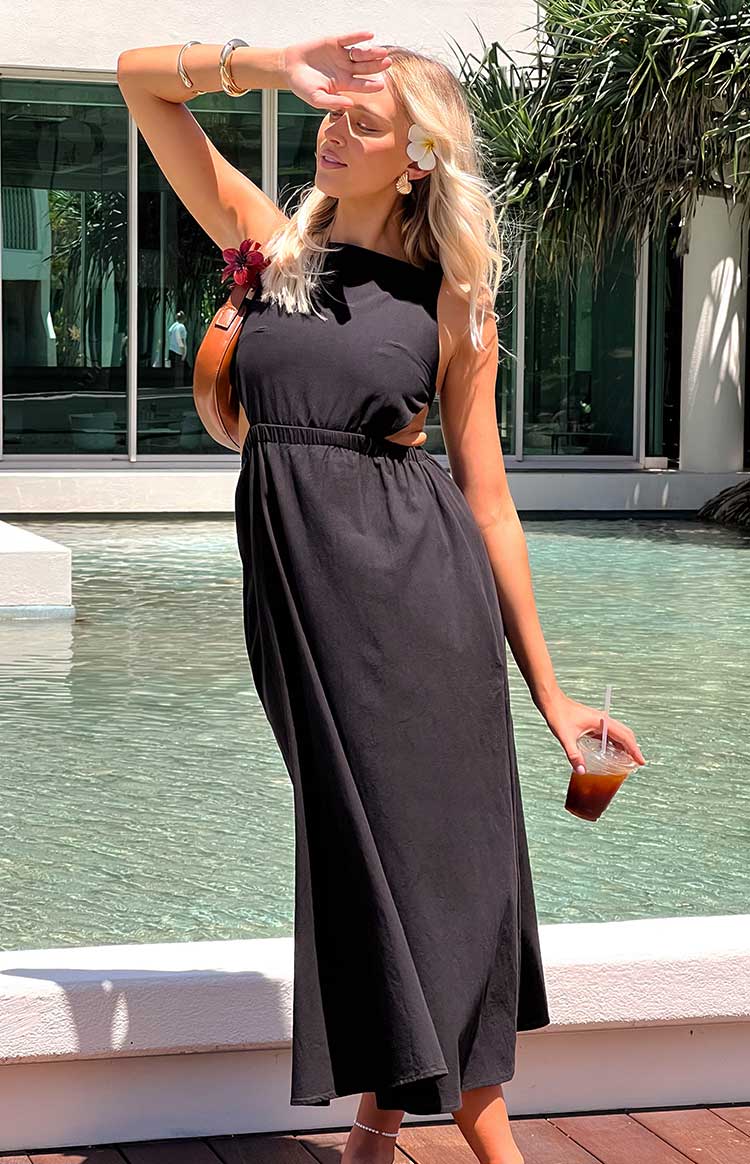 Side view of a black midi dress showing the elasticated waist and side cutouts