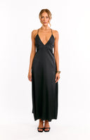 Model wears a black halter neck maxi dress with waist cut outs. This flowy evening gown features a babydoll silhouette. A unique choice for a formal event or a cocktail party.