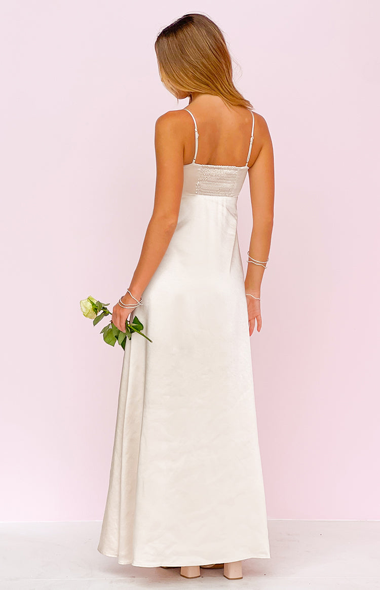 Rear view of a cream satin maxi dress showing the shirred back bodice and thin spaghetti straps