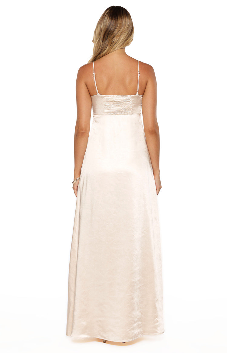 Rear view of a cream satin maxi dress with thin adjustable spaghetti straps and a shirred back bodice