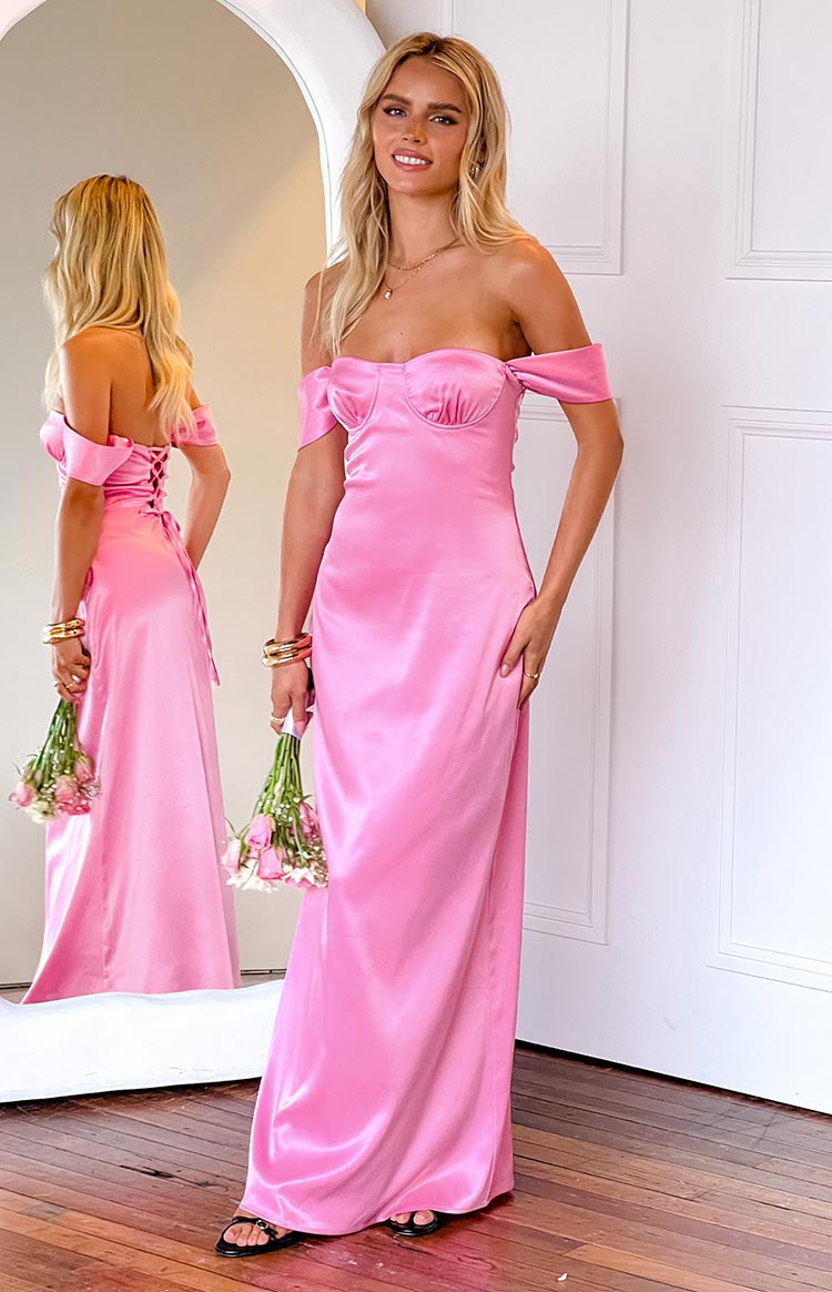 Pink satin off-shoulder maxi dress with a sweetheart neckline, and a mirror reflection showing the lace-up back