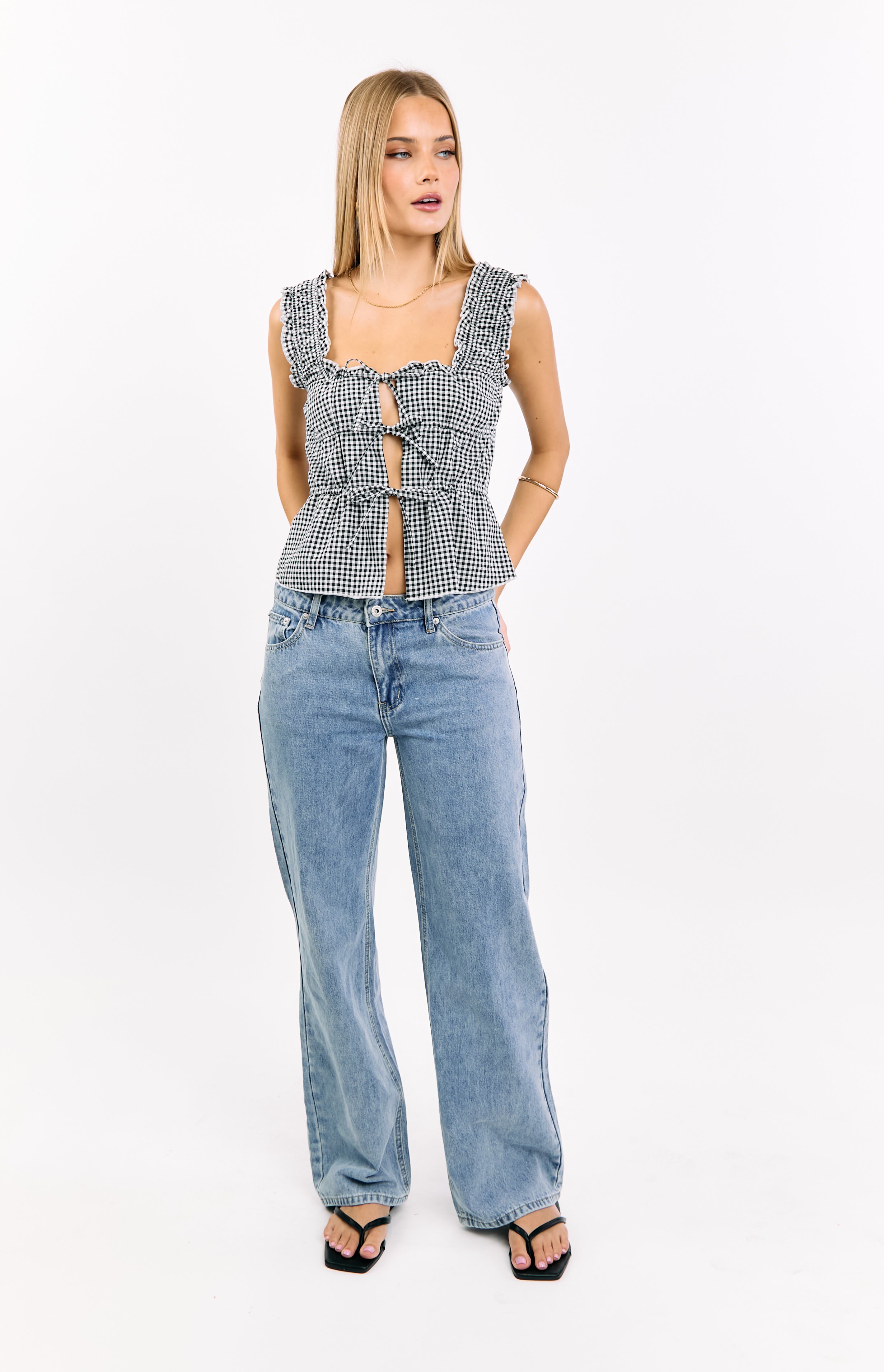 Black gingham crop top with a square neckline, ruffled straps, and multiple ties creating front cutouts