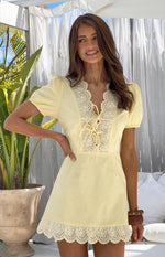 Yellow mini dress with scalloped broderie trim V-neck, lace-up front, puff sleeves, and broderie hem