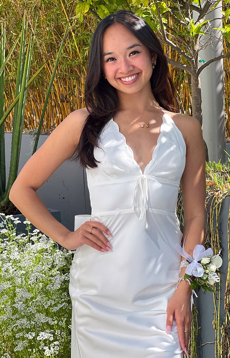 Close-up of the white maxi dress with a scalloped V-neckline and tie-front detail