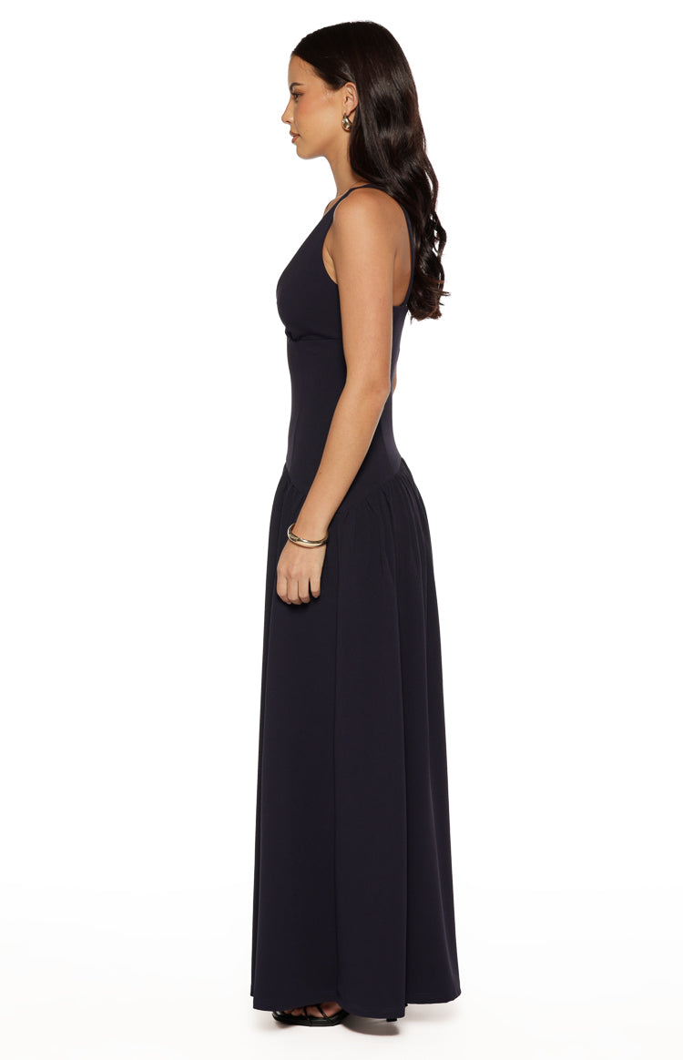 Side view of a navy crepe maxi dress showing the fitted bodice, drop waist, and flowing skirt