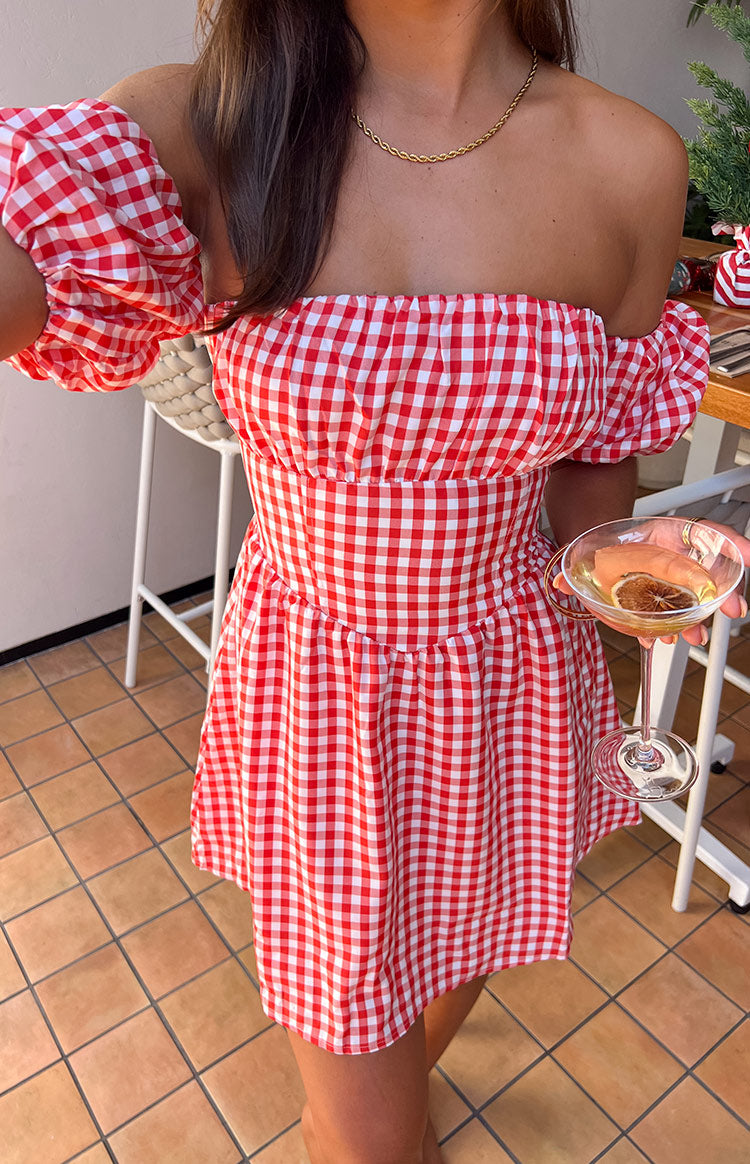 Close-up of the red gingham off-shoulder mini dress showing the shirred bodice and gathered skirt