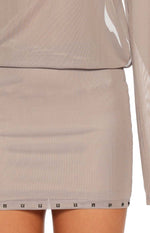 Close-up of the brown sheer mesh mini dress showing the pyramid stud detail along the hem