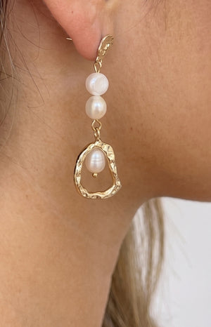 Close-up of the textured gold stud, two round pearls, and irregular gold loop with a pearl drop