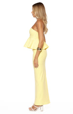 Side profile of a yellow crepe strapless top with a fitted bodice and a ruffled peplum waist