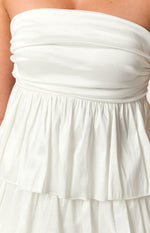 Close-up of the white strapless mini dress showing the ruched bodice, gathered waist, and tiered skirt