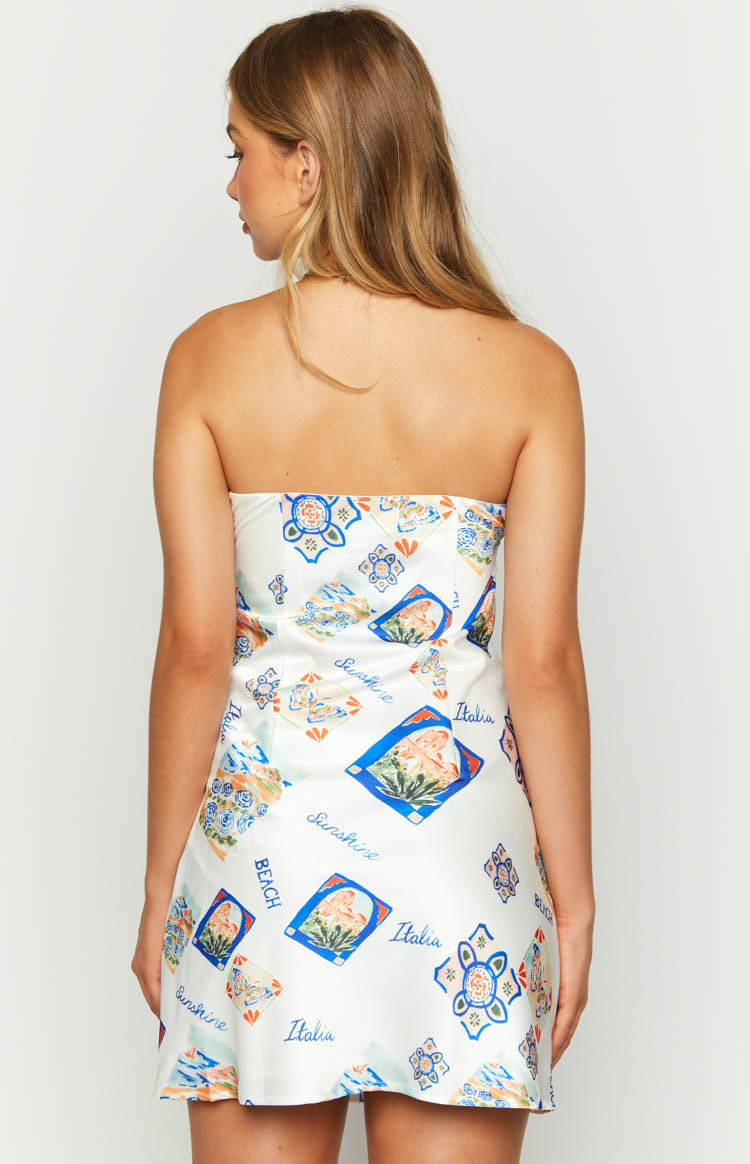 Rear view of a white strapless mini dress with a colourful Italia print featuring blue, orange, and green motifs