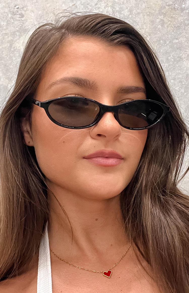 brunette model wearing black cateye frames sunglasses with smokey black lenses