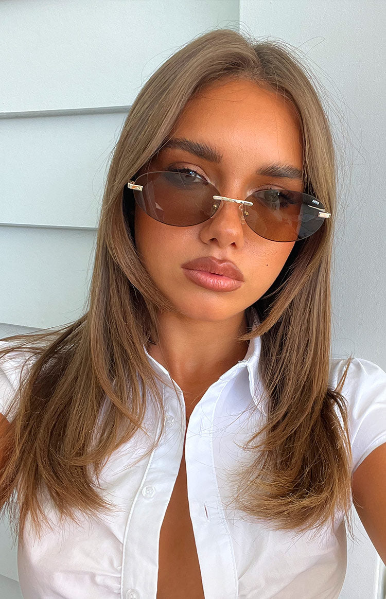 Beginning Boutique Otra Eyewear Jasmine Brown/Gold Metal Frame Oval Sunglasses brown oval sunglasses with gold metal frame and brown tinted lenses