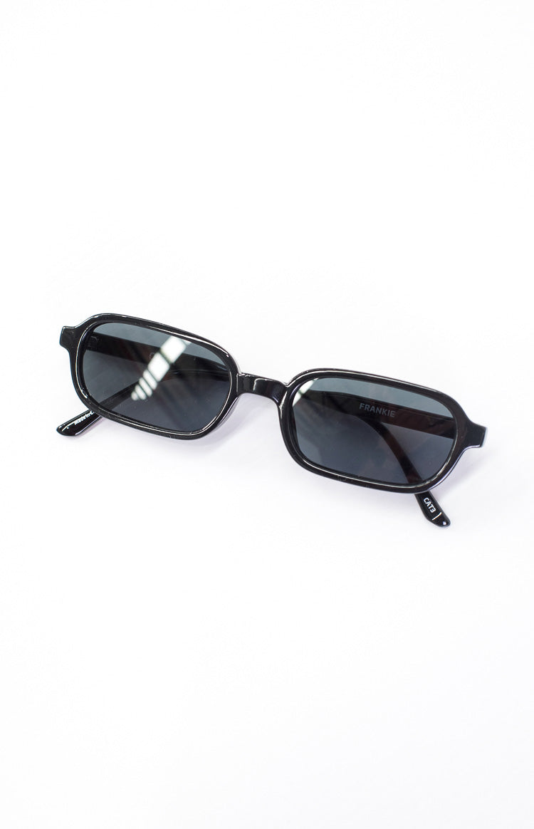 Top-down view of black rectangular sunglasses with dark lenses and one arm folded