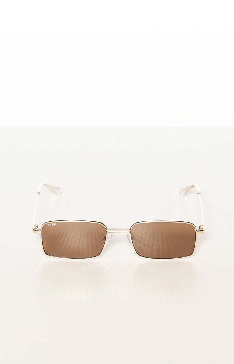 Slightly elevated front view of gold metal square frame sunglasses with brown lenses and OTRA logo
