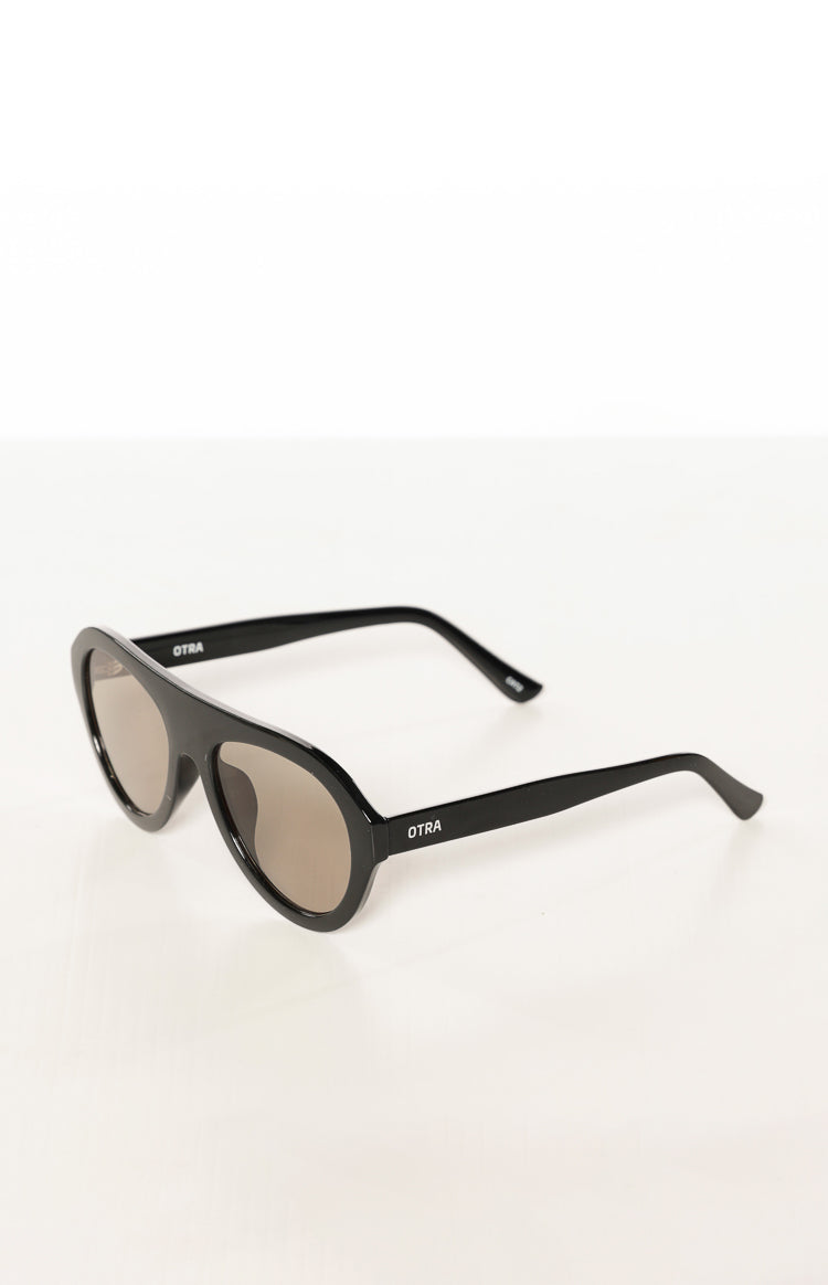 Angled view of black aviator sunglasses with thick frames and the Otra logo on the temple