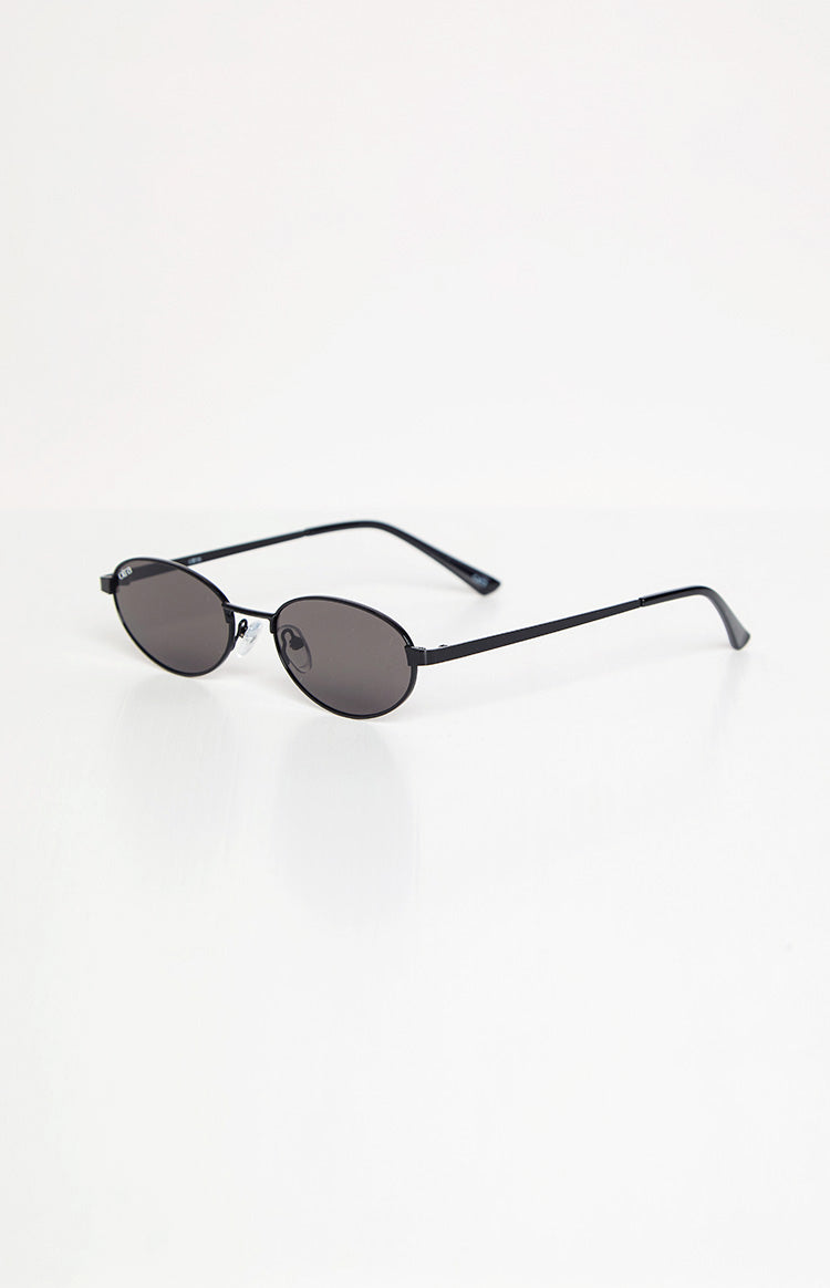Side view of black oval sunglasses with dark lenses and thin metal arms