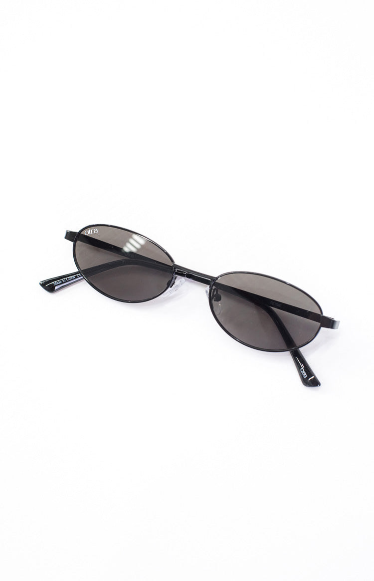 Angled view of black oval sunglasses with dark tinted lenses and thin black frames