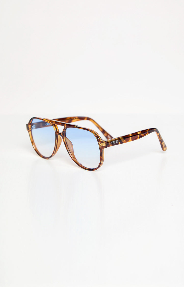Tortoiseshell aviator sunglasses with blue gradient lenses and the Otra logo on the right arm