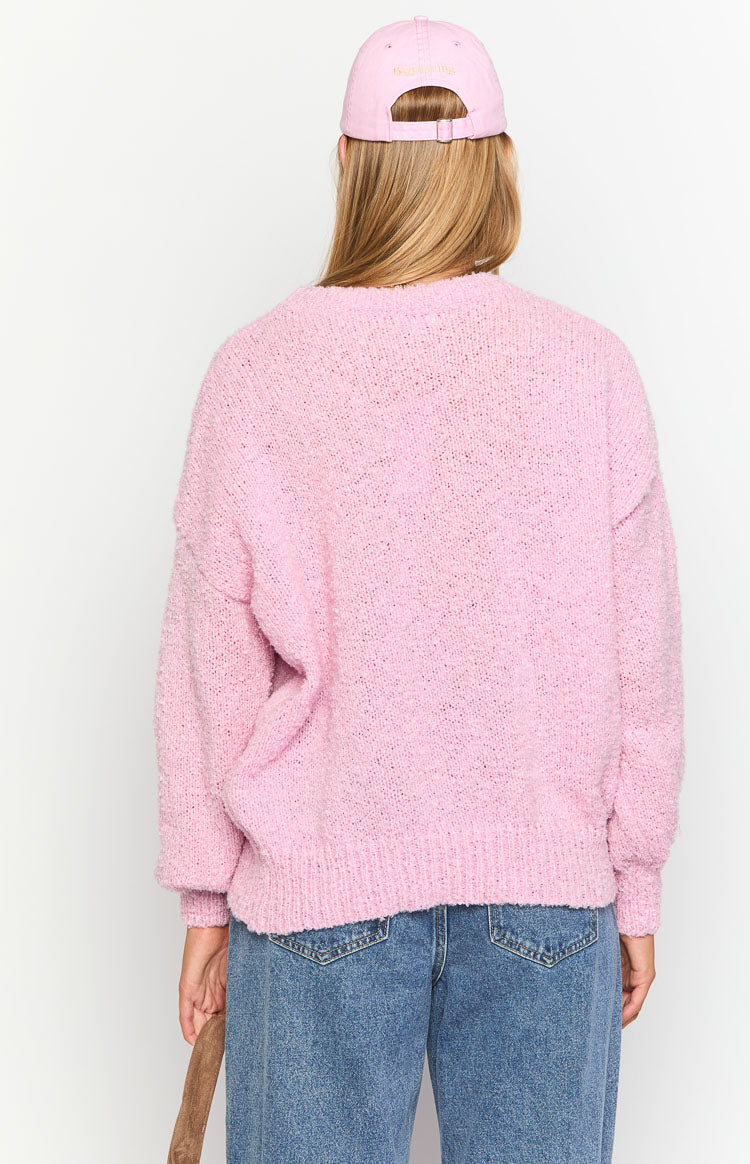 Rear view of a pink knit sweater with a relaxed fit, showing the textured knit and ribbed hem and cuffs