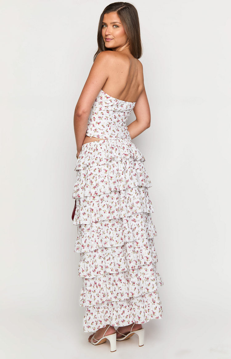 Side view of a white floral maxi skirt featuring cascading tiers of ruffles from waist to hem